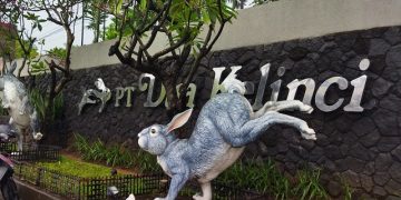 MEMOTRET: Seorang pengendara sedang memotret ikon pabrik Dua Kelinci yang ada di pagar depan ( Istimewa I harianmuria.com)