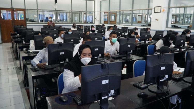 MENGANTRI: Para peserta ujian CAT sedang berbaris untuk diperiksa sebelum masuk ruang ujian ( Istimewa I Harianmuria)