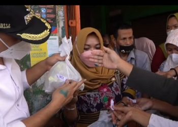 MENDISTRIBUSIKAN: Bupati Jepara Dian Kristiandi membagikan minyak goreng bersubsidi kepada warga.