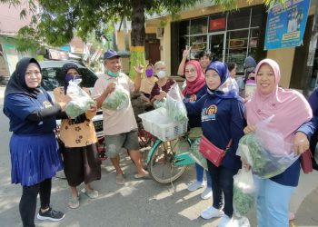 MENERANGKAN: Alumni SMEA Yos Sudarso angkatan tahun 1997 gabi-bagi sayuran hasil kebun gratis di Perempatan Kempong Jl. Dr. Sutomo Rembang, Jum’at (26/8). (R Teguh Wibowo/Harianmuria.com)