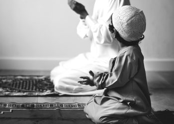 Muslim boy learning how to make Dua to Allah