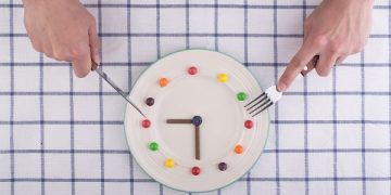 Lunch time concept, clock in plate, knife and fork