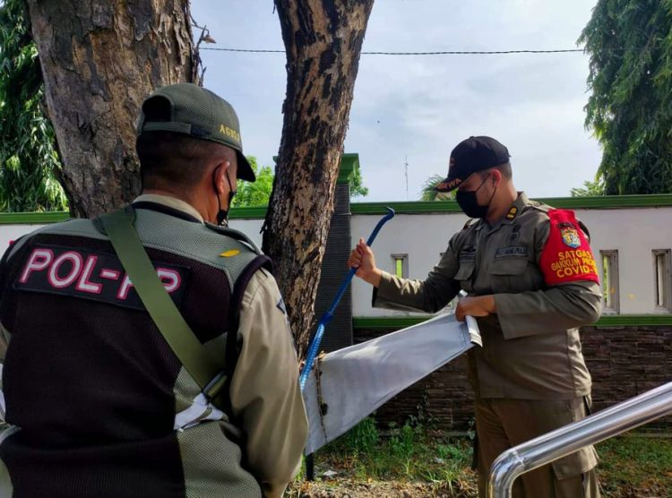 PENERTIBAN: Tim Gabungan Satpol PP Kendal sedang melakukan penertiban reklame yang menyalahi aturan di jalanan. (Arvian Maulana/Harianmuria.com)