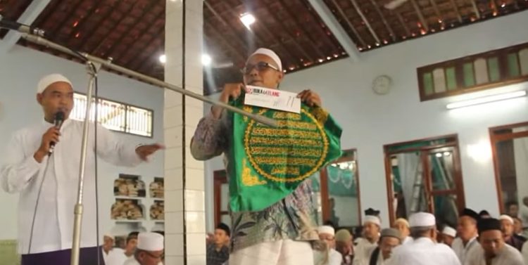 Mengulik Tradisi Lelang Kelambu Makam Waliyullah di Pati - Harianmuria LELANG: Pengelola makam Syekh Ahmad Mutamakkin saat membentangkan kain kelambu. (Istimewa/Harianmuria.com)