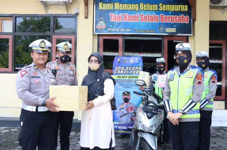 SIMBOLIS: Petugas Operasi Zebra Candi memberikan hadiah kepada pengemudi yang tertib saat berlalu lintas melalui program "Jepret Berhadiah". (Arvian Maulana/Harianmuria.com)