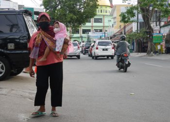Salah satu PGOT yang menggendong anaknya di Kabupaten Kudus. (Hasyim Asnawi/Harianmuria.com)