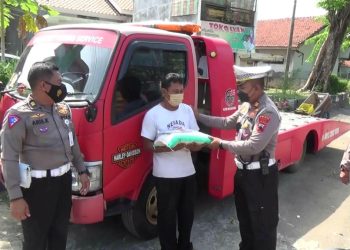 Kapolres Kendal AKBP Jamal Alam membagikan sembako kepada masyarakat. (Arvian Maulana/Harianmuria.com)