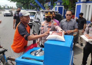 AKBP Dandy Ario Yustiawan menyerahkan sembako beras ke pedagang es keliling. (R Teguh Wibowo/Harianmuria.com)