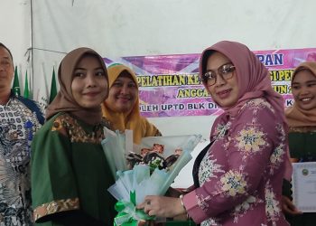 SIMBOLIS: Ketua TP PKK Blora Ainia Shalichah (kanan, pink) saat memberikan cinderamata kepada salah satu peserta pelatihan di BLK, Minggu (16/1). (Istimewa/Harianmuria.com)