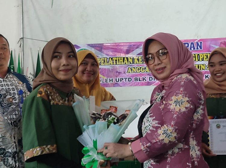 SIMBOLIS: Ketua TP PKK Blora Ainia Shalichah (kanan, pink) saat memberikan cinderamata kepada salah satu peserta pelatihan di BLK, Minggu (16/1). (Istimewa/Harianmuria.com)