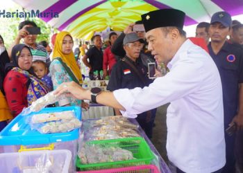 MENGUNJUNGI: Pj Bupati Jepara Edy Supriyanta terlihat memborong olahan ikan di salah satu stand dalam acara Festival Ikan Asap dan Hasil Laut. (Muslichul Basid/Harianmuria.com)