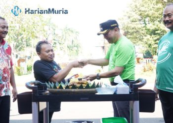 SIMBOLIS: Pj Bupati Jepara Edy Supriyanta memberikan potongan tumpeng kepada salah satu penyandang disabilitas. (Muslichul Basid/Harianmuria.com)
