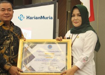 PRESTASI: Kepala Diskominfo Kabupaten Kudus Dwi Yusi Sasepti saat menerima penghargaan sebagai OPD Terbaik dalam Penyelenggaraan Keterbukaan Publik dari PWI Kudus di Hotel @HOM, Kamis (1/12). (Nisa Hafizhotus Syarifa/Harianmuria.com)