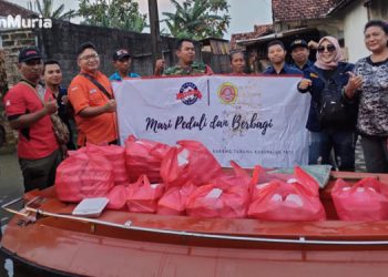 Karang Taruna Kabupaten Pati saat mendistribusikan bantuan nasi bungkus di tengah banjir. (Istimewa/Harianmuria.com)