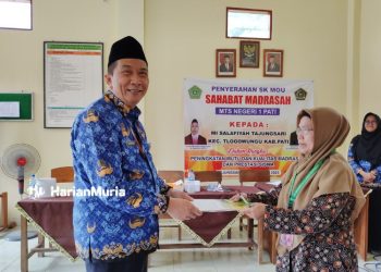 BANGGA: Kepala MI Darussalam Tlogowungu Merianq Tismawanti (kanan) saat menerimanya piagam penghargaan dari Kepala MTsN 1 Pati Ali Musyafak (kiri) di Kantor MTSN 1 Pati, Selasa (19/12/2023). (Arif Febriyanto/Harianmuria.com)