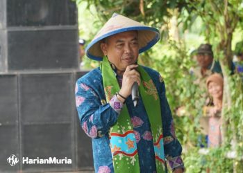 PAKAI CAPING: Pj Bupati Jepara Edy Supriyanta saat menyampaikan sambutan dalam acara tradisi Umbul Donga Wiwit Pari atau Festival Kenduri Tani 2024 di Desa Telukawur, Kecamatan Tahunan, Kabupaten Jepara, Kamis (25/4/2024). (Tomi Budianto/Harianmuria.com)