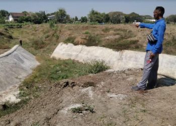 MULAI DIPERBAIKI: Tampak sejumlah pekerja mulai melakukan perbaikan pasca pemberitaan rusaknya embung Nglebok-Cepu. (Hanafi/Harianmuria.com)