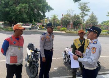 Anggota Dinas Perhubungan (Dishub) Kabupaten Pati tengah menyambangi juru parkir yang ada di Alun-alun Pati baru-baru ini. (Setyo Nugroho/Harianmuria.com)