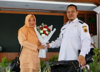 Momen Camat Dukuhseti  Agus Sunarko, S.STP., M.Si. memberikan hadiah berupa buket bunga kepada sang istri Irma Agus Sunarko di momoen HUT ke-25 DWP di Pendopo Kabupaten Pati pada Rabu, 11 Desember 2024. (Mutia Parasti/Harianmuria.com)