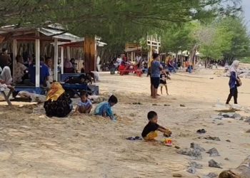 ASYIK BERWISATA: Sejumlah anak-anak sedang bermain pasir di Pantai Pasir Putih Wates, Desa Tasikharjo, Kecamatan Kaliori, Kabupaten Rembang. (Vicky Rio/Harianmuria.com)