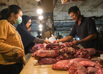 Pembeli daging sapi di salah satu pasar wilayah Kabupaten Rembang, sedang memilih daging di salah satu kios pedagang. (Lingkar Network | Harianmuria.com)