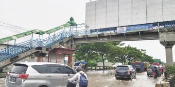 Sejumlah kendaraan mengurangi laju kendaraan ketika melewati banjir di jalan raya Kaligawe, Kota Semarang, Senin (3/2). (Syahril Muadz | Harianmuria.com)