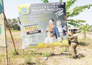Petugas Satpol PP Kabupaten Semarang sedang berusaha mencabut reklame yang menyalahi aturan di Ungaran, Kabupaten Semarang, Kamis (6/2). (Hesty Imaniar | Harianmuria.com)