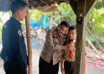 Kapolsek Tlogowungu AKP Mujahid memeluk adik AAP saat pulang dari sekolah baru-baru ini. (Istimewa/Harianmuria.com)