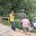 Sejumlah relawan membantu masyarakat menyeberangkan sepeda motor melalui tali gantung di Jembatan Tembelan, belum lama ini.(Istimewa/Harianmuria.com)