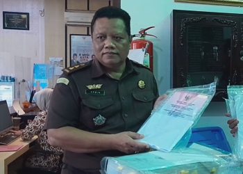 Kasi Pidana Khusus Kejari Pati Erwin Adriyanto menunjukkan barang bukti penggelapan yang diduga dilakukan tersangka. (Mutia Parasti/Harianmuria.com)