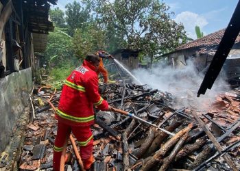 Petugas memadamkan sisa api yang membakar rumah warga di Tlogorejo, Karangawen, Pati. (Burhan Aslam/Harianmuria.com)