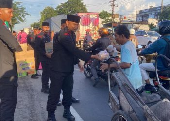 Personel Brimob membagikan takjil kepada pengguna jalan di depan Mako Brimob Kalibanger, Kota Pekalongan. (Fahri Akbar/Harianmuria.com)