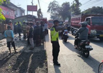 Polisi mengatur lalu lintas ketika warga menonton bangunan warung bakso yang terbakar. (Dok. Polres Salatiga/Harianmuria.com)
