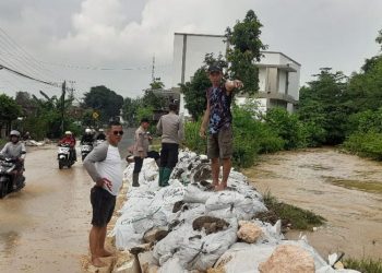 Anggota Polsek Gabus bersama warga menangani tanggul jebol di Sungai Gono, Desa Penanggungan, Kecamatan Gabus, Kabupaten Pati, Sabtu (26/4/2025). (Setyo Nugroho/Harianmuria.com)