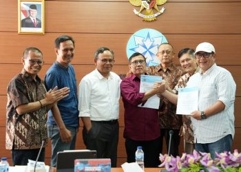 Ketua PWI KLB Zulmansyah Sekedang berjabat tangan dengan Ketua PWI Kongres Bandung Hendry Ch Bangun, disaksikan jajaran Dewan Pers usai penandatanganan SK Panitia Bersama Kongres Persatuan PWI.
(Istimewa/Harianmuria.com)