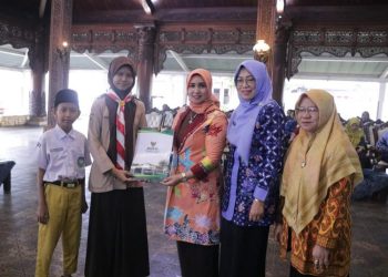 Laila Saidah Witiarso Utomo menyerahkan bantuan pendidikan kepada penerima bantuan LGNOTA. (Tomi Budianto/Harianmuria.com)
