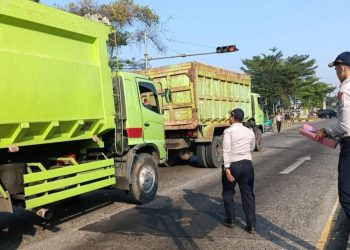 Petugas Dishub Kota Pekalongan melakukan penyekatan kendaraan berat di jalur pantura sekitar Exit Tol Setono sebagai bagian dari penegakan aturan larangan truk siang hari, Selasa, 24 Juni 2025. (Fahri Akbar/Harianmuria.com)
