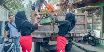 Dua orang pelajar mengangkat sampah ke atas truk saat Resik-Resik Kutho yang digelar Pemkot Salatiga di lingkungan Kalioso, Jumat, 13 Juni 2025. (Dok. Setda Salatiga/Harianmuria.com)