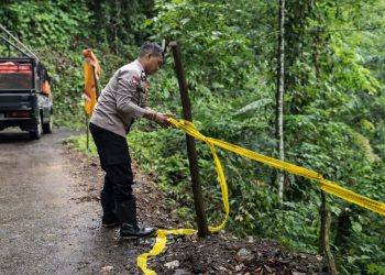 Jalur Doro–Petungkriyono di Pekalongan rawan longsor dan licin, polisi memasang garis pengaman di tepi jurang.