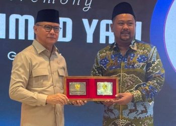 Menteri Pelindungan Pekerja Migran Indonesia (P2MI) Mukhtarudin (kiri) menyerahkan penghargaan kepada Bupati Gresik Fandi Akhmad Yani di Jakarta, Senin (27/7/2026). (Dok. KP2MI)