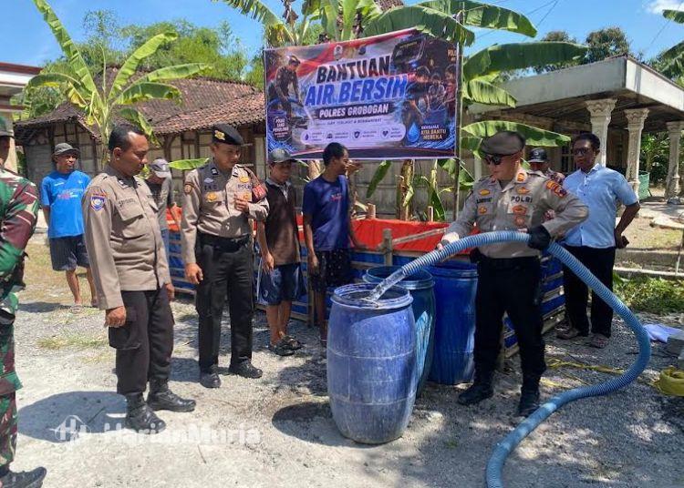 Desa Cingkrong Grobogan Terdampak Kekeringan, Bantuan Air Bersih Mulai Didistribusikan - Harianmuria Tampak personel Polres Grobogan menyalurkan bantuan air bersih kepada warga Dusun Widuri, Desa Cingkrong, Kecamatan Purwodadi, Kabupaten Grobogan, Kamis (23/7). (Ahmad Abror/Harianmuria.com)