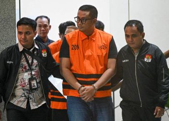 Bupati Klaten Hamenang Wajar Ismoyo (tengah) berjalan menggunakan rompi tahanan usai menjalani pemeriksaan di Gedung Merah Putih KPK, Jakarta, Jumat (16/10/2026).